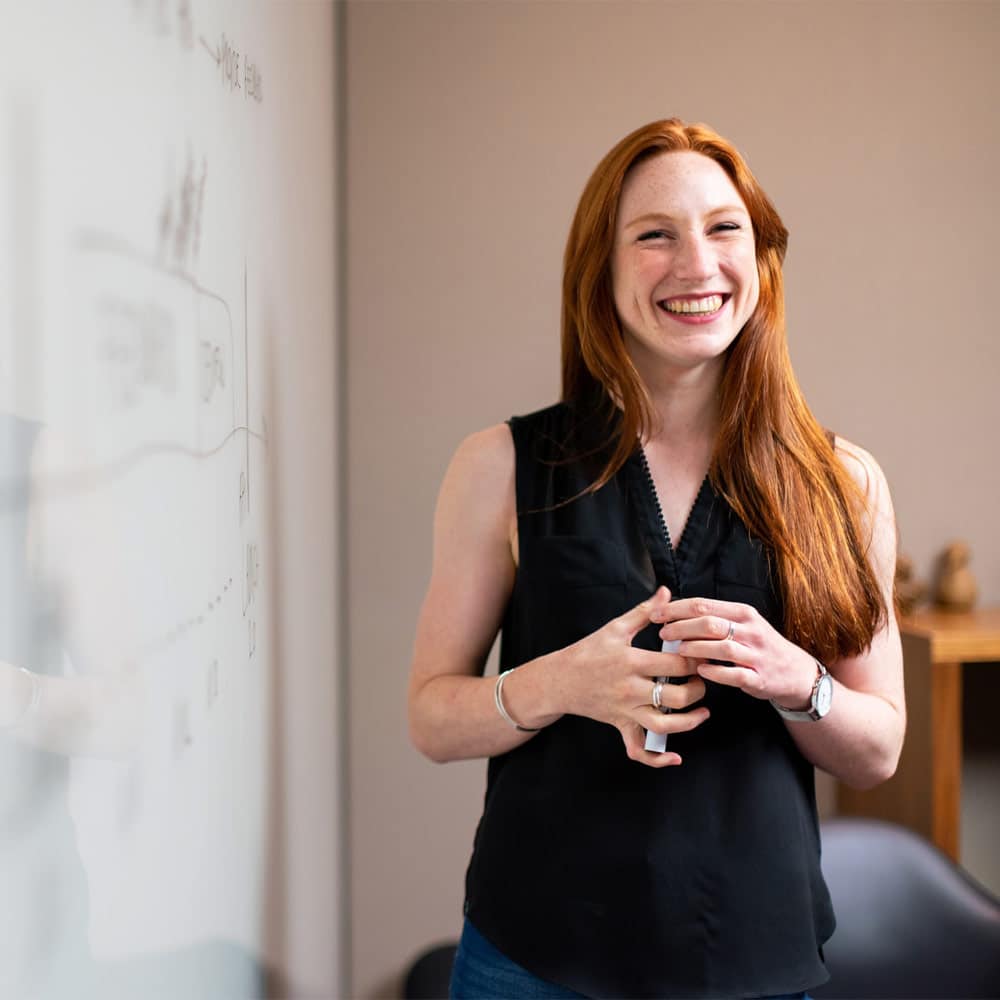 Smiling lady standing at a whiteboard